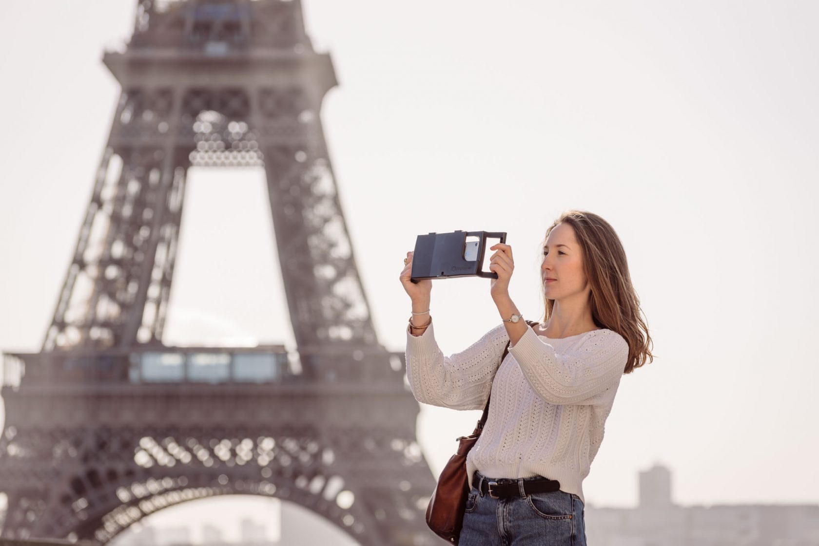 lifestyle product photoshoot in Paris France for iOgrapher, model in front of the Eiffel tower holding iPhone filming case