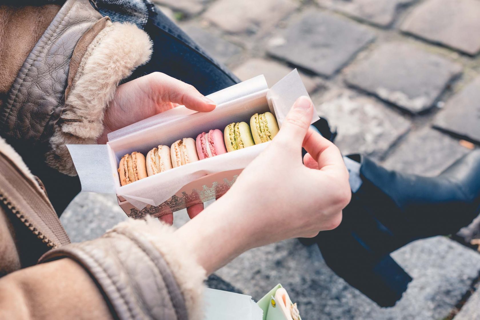 Paige Gribb Photography in Paris, France: lifestyle photo of woman's hands holding box of Ladurée macarons