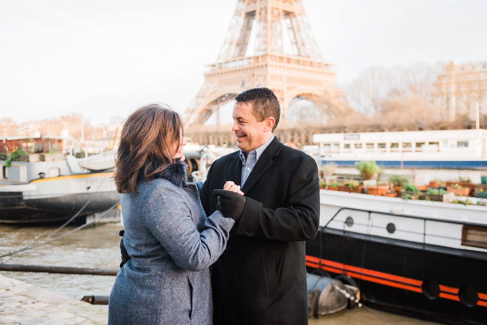 professional photography in paris france - couple dancing together by the seine river on an anniversary photoshoot