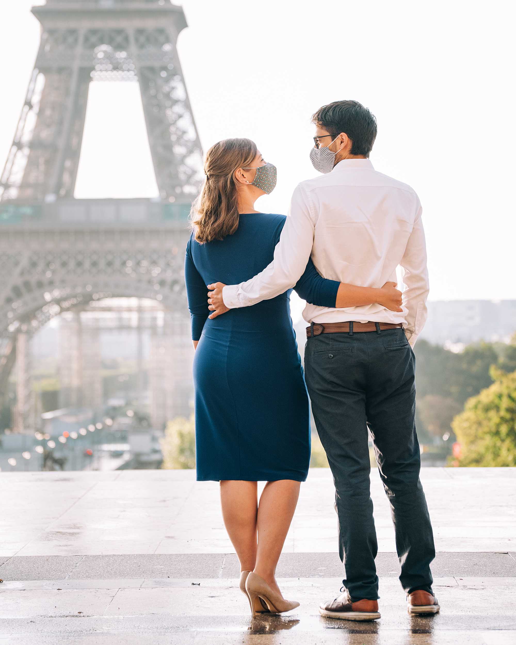 Couple's romantic photo shoot in Paris at the Eiffel Tower, both wearing masks during covid-19. Shot by Paige Elizabeth Gribb